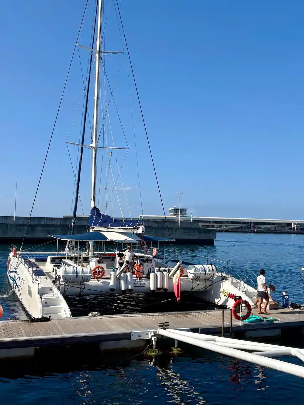 The catamaran alongside the marina pontoon