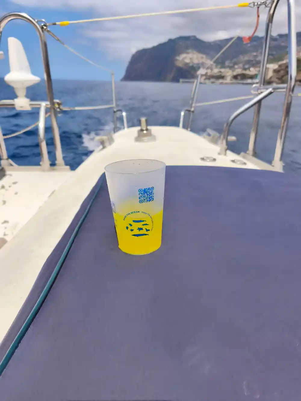 A drink in a reusable cup resting on the deck