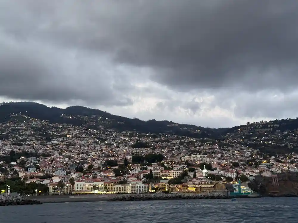 Funchal climbing its hillside under heavy grey cloud