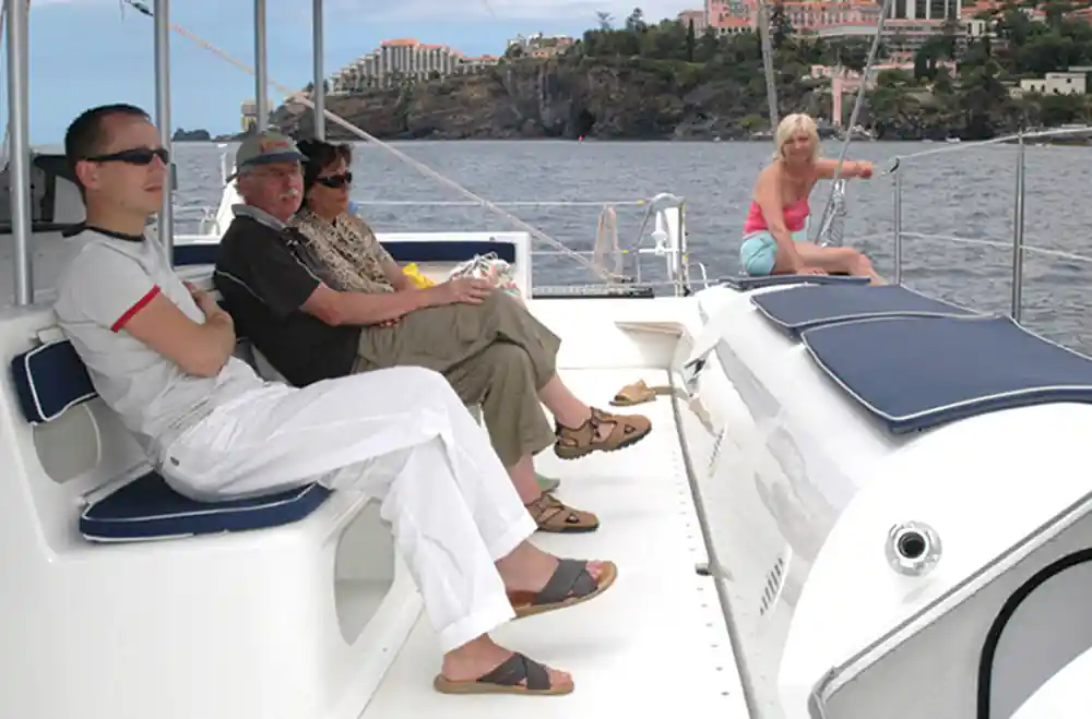 Guests seated along the side deck in the sun