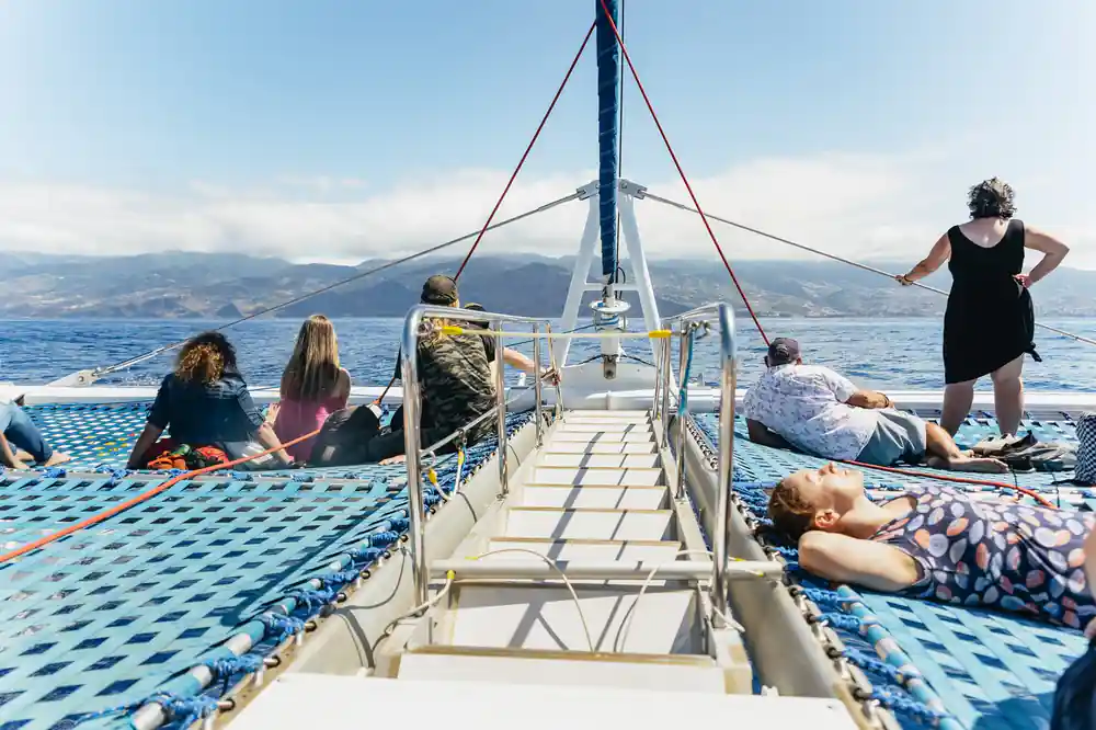 Passengers spread across the foredeck nets under the mast